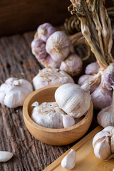 Fresh Garlic Bulbs and Cloves in Wooden Bowl on Rustic Background