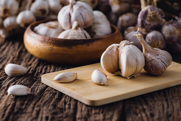Fresh Garlic Bulbs and Cloves on Wooden Cutting Board Surface