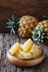 Fresh Pineapple Chunks in Wooden Bowl with Tropical Background