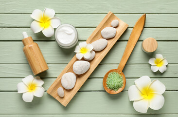 Beautiful spa composition with tray, plumeria flowers, stones, jars and bottle of cosmetic products...