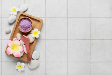 Obraz na płótnie Canvas Beautiful spa composition with tray, stones, plumeria flowers and bowl with sea salt on beige tile background