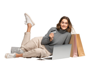  a woman lying on the floor with a laptop, holding a credit card in one hand and shopping bags near her leg, with a smiling face, on a transparent background, in png format.