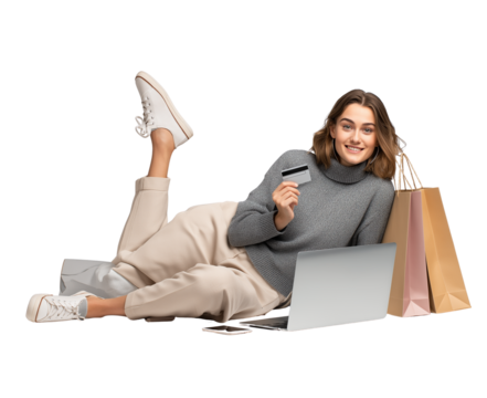  a woman lying on the floor with a laptop, holding a credit card in one hand and shopping bags near her leg, with a smiling face, on a transparent background, in png format.