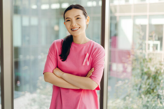 Young woman wearing pink ribbon supporting breast cancer awareness campaign