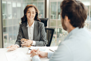 Businesswoman holding chihuahua discussing with businessman in office