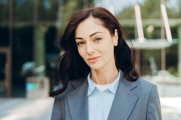 Confident businesswoman smiling outside office building