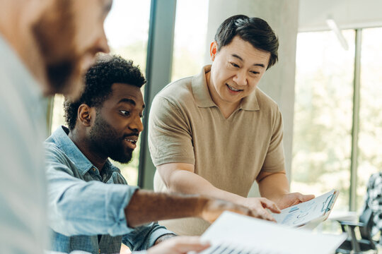 Diverse of multinational businessmen analyzing financial charts during meeting