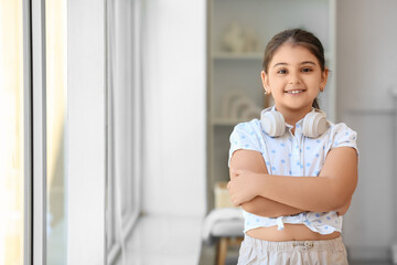 Little girl with headphones at home