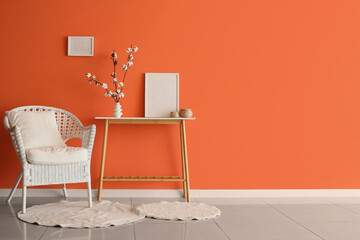 Interior of living room with cotton flowers in vase on table and armchair
