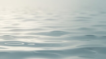 Water surface: A minimalist, abstract image capturing the serene essence of water in its purest form, with gentle ripples reflecting the subtle interplay of light and shadow.