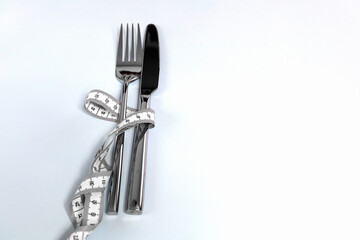 Fork and knife wrapped in a measuring tape