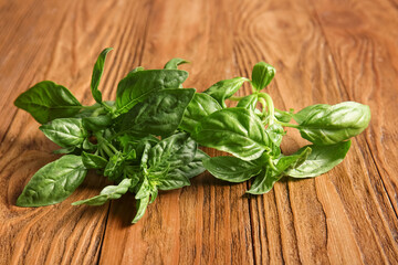 Fresh green basil leaves on wooden background, closeup