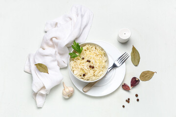 Bowl with tasty sauerkraut and different ingredients on white background
