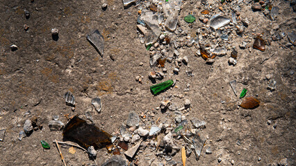 Broken glass shards on asphalt with gravel