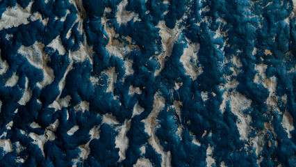 Blue and white textured wall with peeling paint