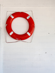 Red Lifebuoy Hanging on a White Wooden Wall