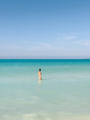 Obraz premium Woman Standing Alone in the Turquoise Sea
