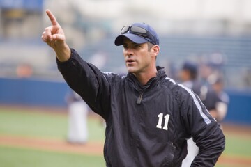 Baseball Coach Giving Instructions on the Field to Players in Uniform