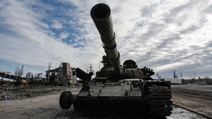 destroyed houses and a military tank on the street of Kiev during the war in Ukraine