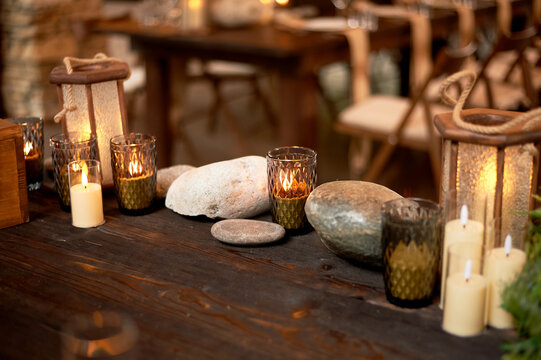 Handmade wooden lanterns and large stones in the d cor of the wedding table in the style of Vikings and warriors. Tree.