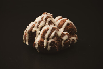 Profiteroles with coconut cream on a black background.