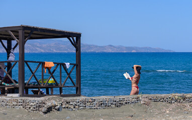 Relaxing on the Beach: Woman in Red Swimsuit Reading Book