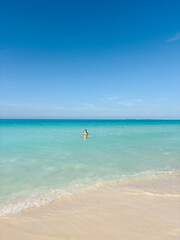 Woman and Calm Waves on a Tropical Beach