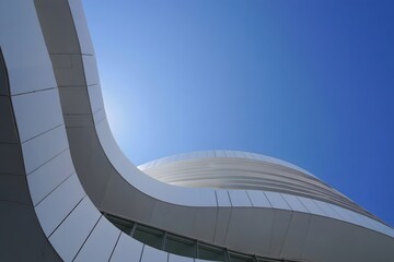 Architectural marvel: modern building design with curved lines against clear blue sky background