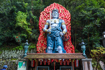 Dazaifu's powerful Nio guardian statue in a serene forest.