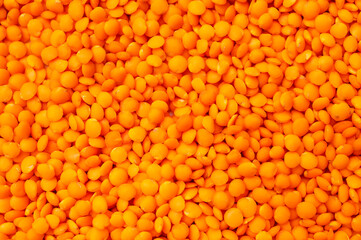 Red raw lentils close-up. Orange lentil background. Abstract food background, pattern. Organic healthy cereal, natural source of plant protein