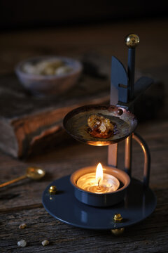 Incense Resin Burning in Censer on Rustic Table with Warm Lighting