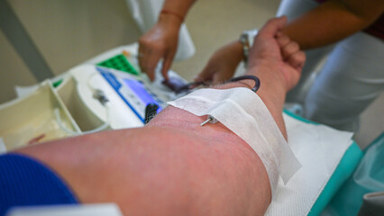 Medical professional performing a blood draw using specialized equipment in a hospital setting