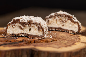 halved marshmallows in chocolate sprinkled with coconut chips, sweet dessert marshmallows in milk chocolate with coconut cut in half