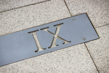 Roman numerical number nine made of stone tiles on street