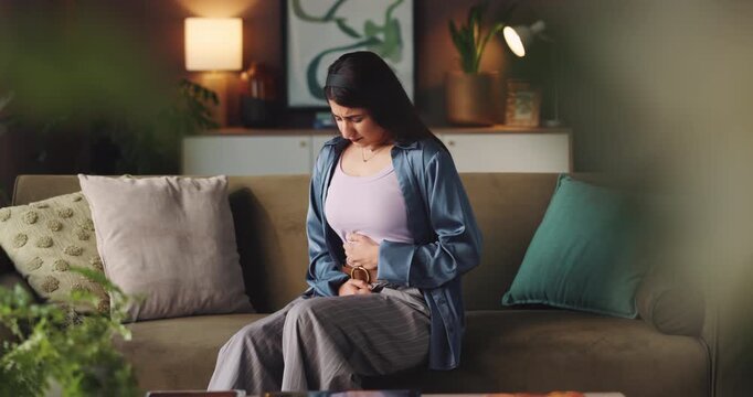 Woman, stomach ache and massage on sofa, home and indigestion with constipation in living room. Person, menstruation and pain with belly, sick or endometriosis with cramps, IBS or gastro at apartment