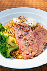 angle view instant noodles with luncheon meat and fried egg at vertical composition