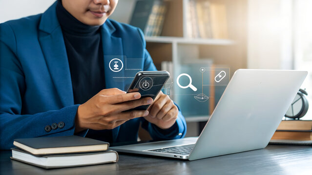 Focused businessman using smartphone and laptop, accessing digital information and achieving goals in modern office environment