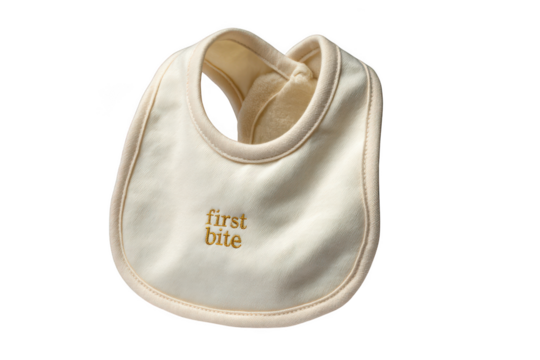 A simple beige baby bib with first bite text is isolated on transparent background