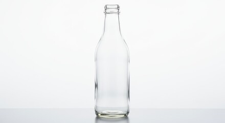 A clear, empty glass bottle, standing upright, against a plain white background.