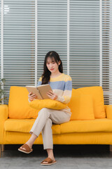Woman Reading Book on Yellow Sofa