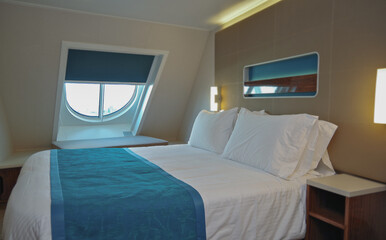 Doppelbett mit Dekokissen vor Schiebetür in Balkonkabine auf Kreuzfahrtschiff - Modern interior...