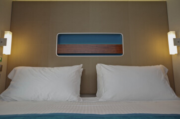 Doppelbett mit Dekokissen vor Schiebetür in Balkonkabine auf Kreuzfahrtschiff - Modern interior...