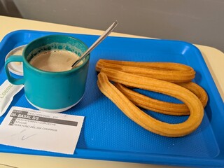 Vista de cerca de bandeja de comida para paciente de hospital. Desayuno con churros servido en la cama del hospital