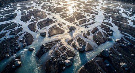 High-angle drone view of vast glacial meltwater forming intricate braided river patterns over ancient bedrock, with icy blue water, dark granite, and ethereal light shafts.