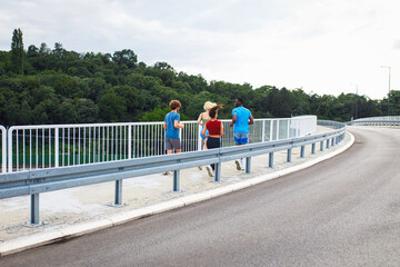 Rear view of group of people running together on outdoor road.