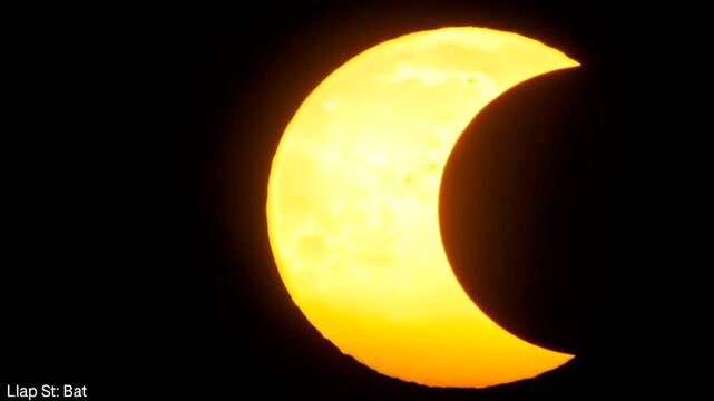 A captivating view of the sun during a solar eclipse, showcasing a crescent shape against a dark night sky.