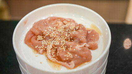 Marinated pork or chicken meat served in the dish for BBQ grilling meal. Food and object photo, close-up.