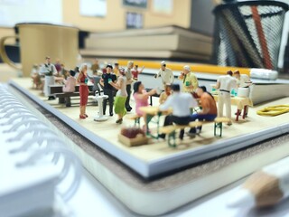 Mini toy of action figure at table with blurred background. Diorama miniature photography concept...