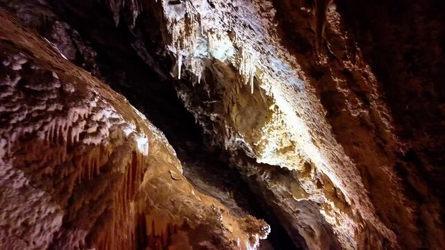 A scenic and illuminated view of the caverns inside Lewis and Clark Caverns State Park is captured, highlighting the stunning geological formations and the unique lighting that enhances their beauty