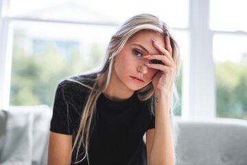 Portrait beautiful young woman at home on the living room with black shirt look sad